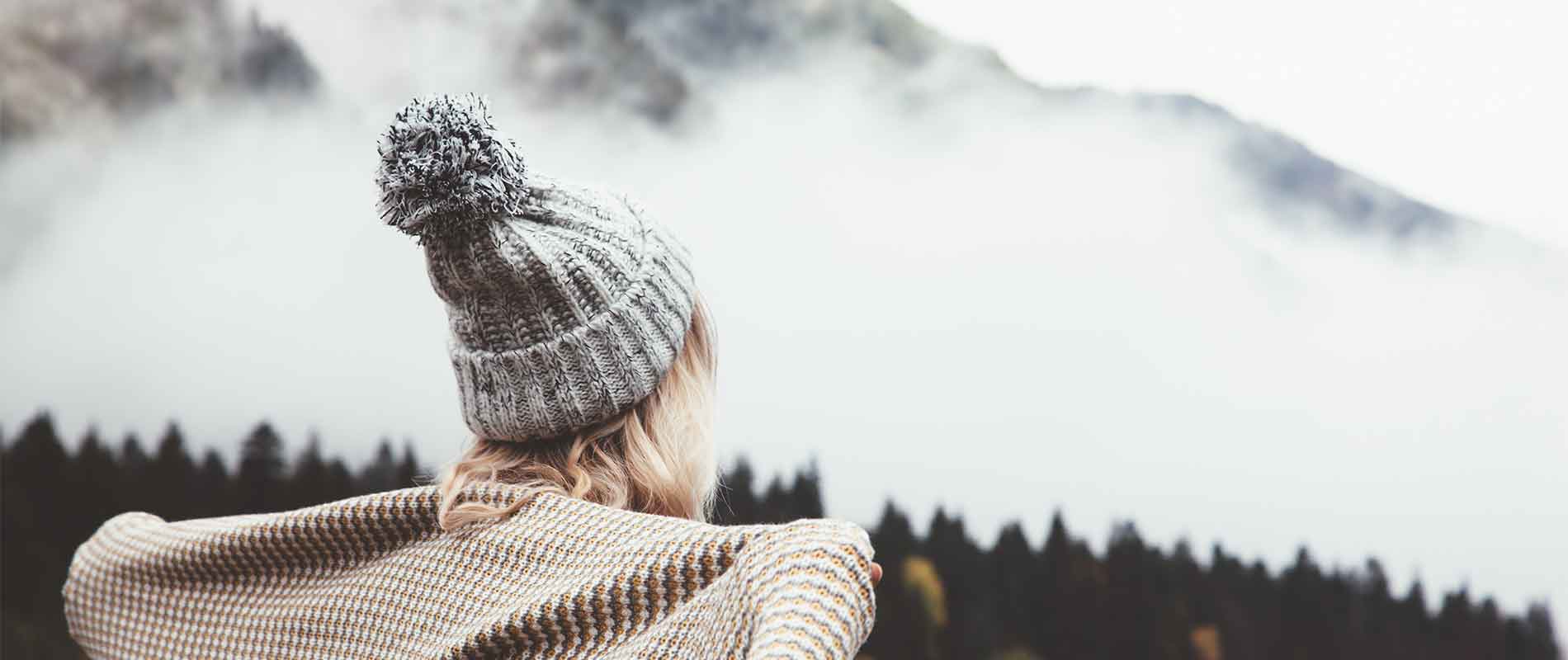 Girl staying warm in wintry setting wearing a knitted bobble hat