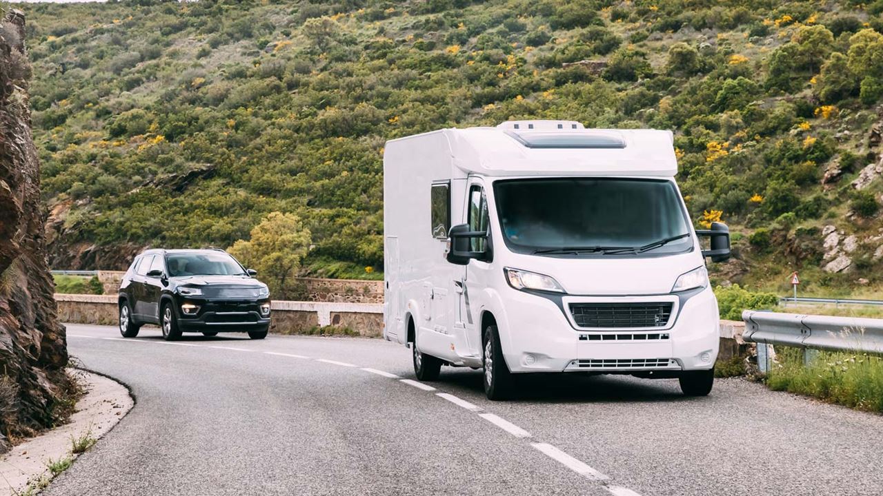 Hired motorhome driving on main road in country valley