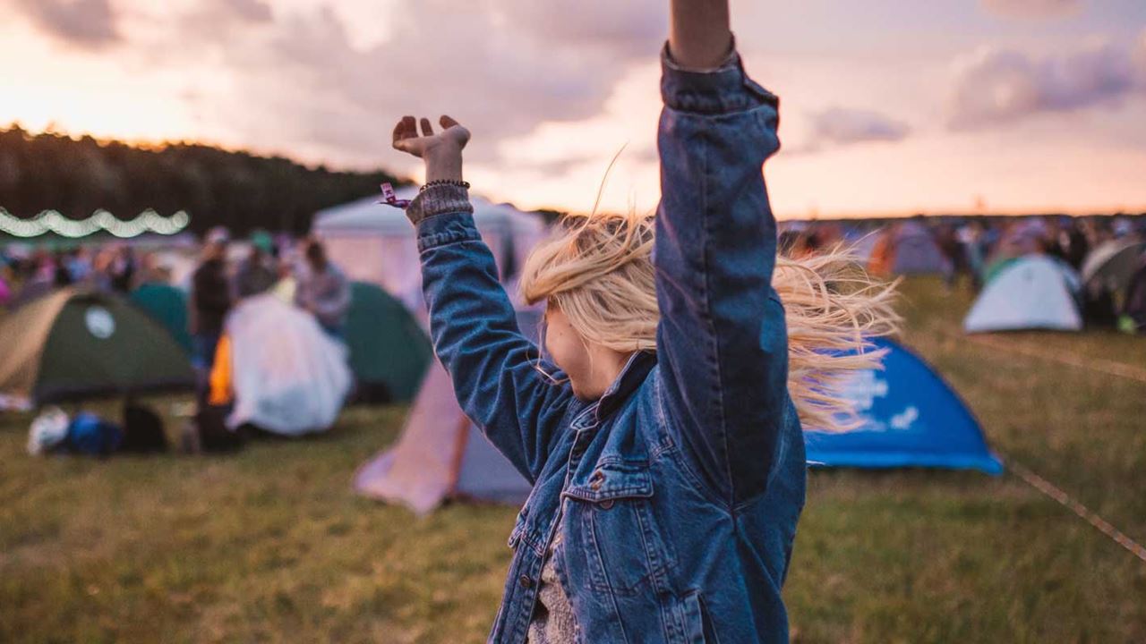 Girl dancing around tents at a UK festival