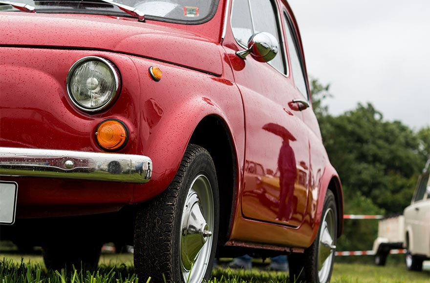 Close up of a red classic Fiat 500 at a classic car show