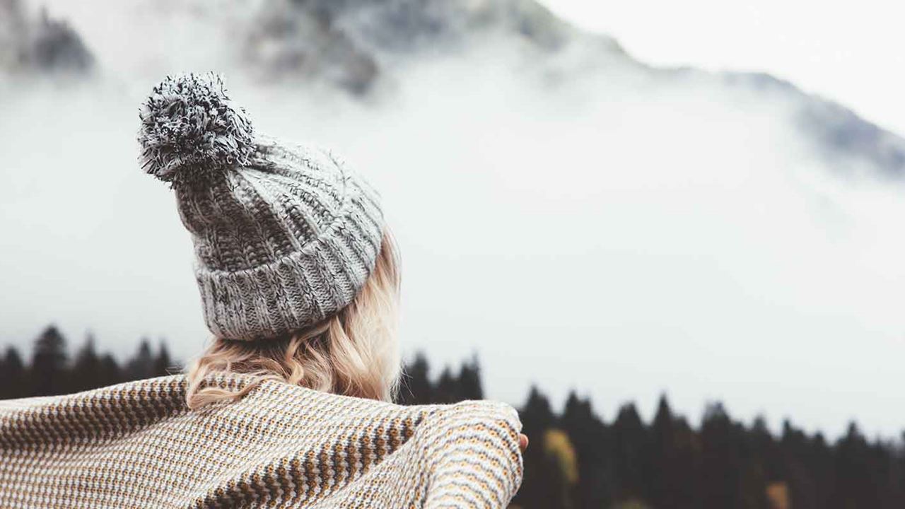 Girl staying warm in winter dry setting wearing a knitted bobble hat