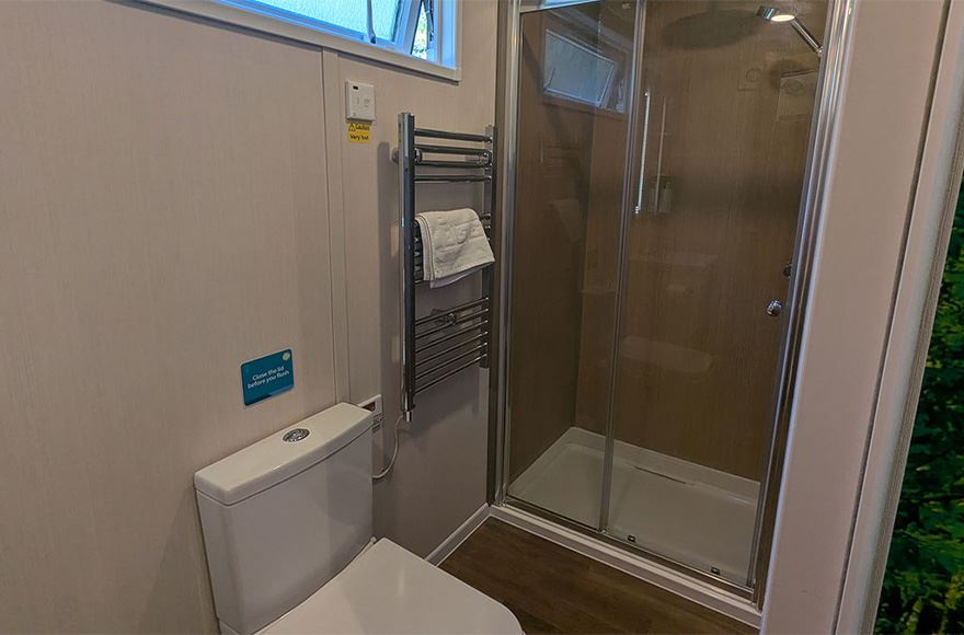 A view of the toilet and shower in the glamping pod bathroom at Abbey Wood campsite, London