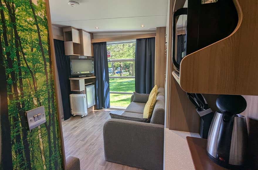 An interiro image of a glamping pod at Abbey Wood campsite, London. Looking from the kitchenette area onto the main pod room