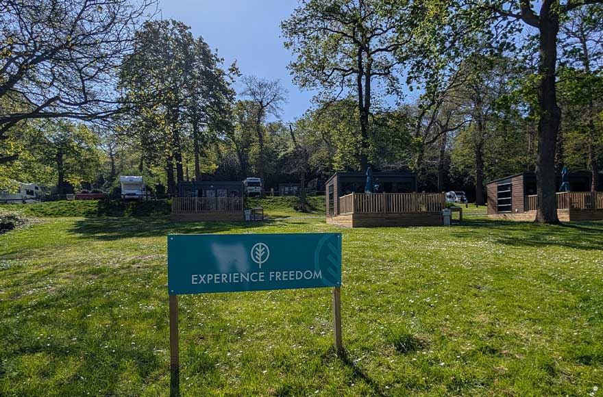 Experience Freedom glamping pods at Abbey Wood campsite, London. Under a lovely blue sky and lots of green trees