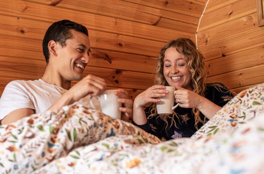 couple enjoying a hot drink in bed