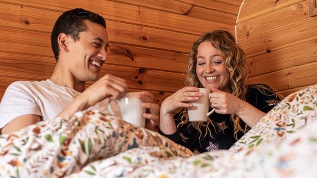 couple enjoying a hot drink in bed