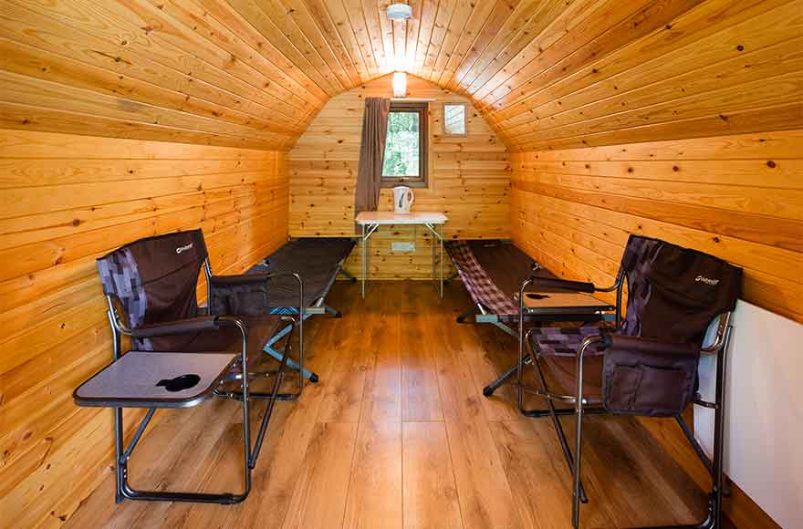 inside view on the camping pod showing beds and chairs