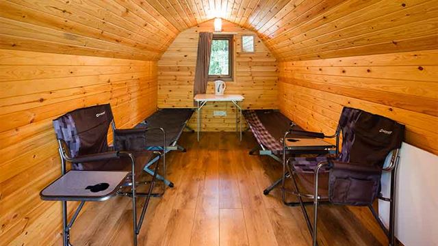 inside view on the camping pod showing beds and chairs