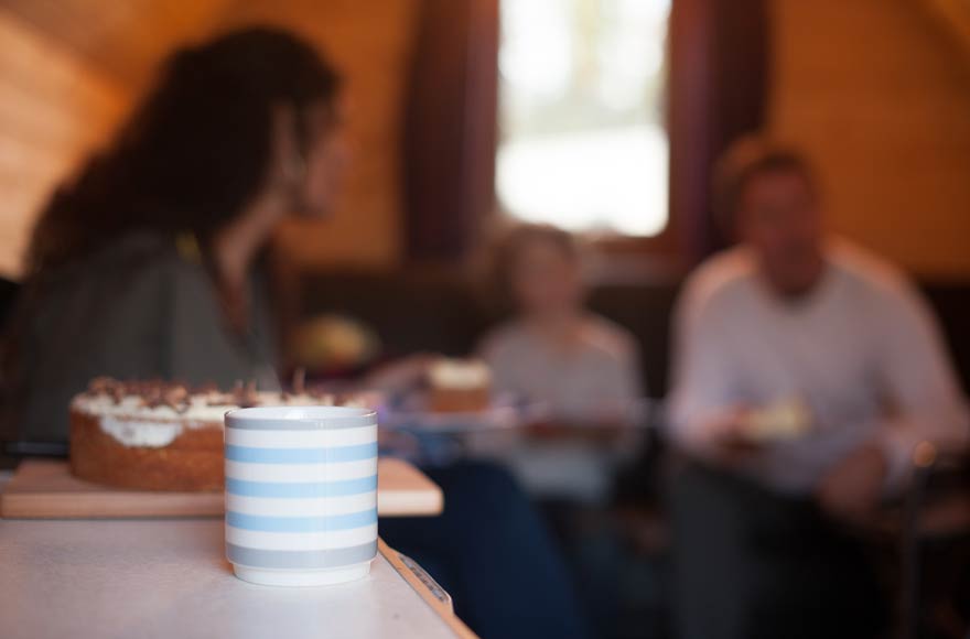 Focused image of a coffee cup with friends in the background