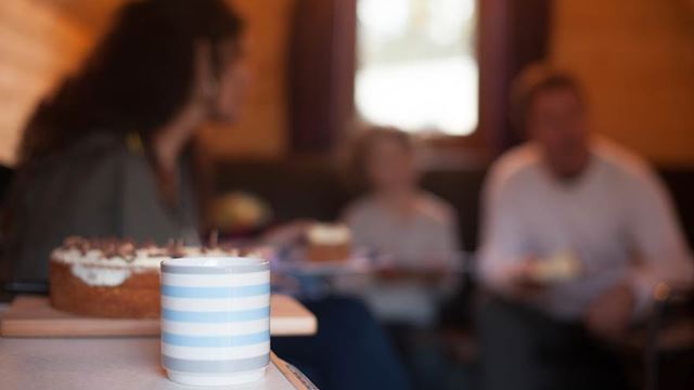 Focused image of a coffee cup with friends in the background