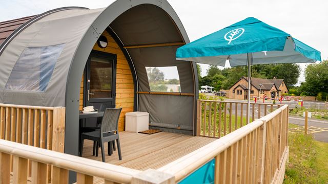 Wooden deck with table and umbrella, perfect for outdoor dining and relaxation