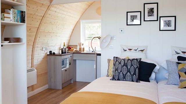 Interior of glamping pod showcasing a bed and kitchen