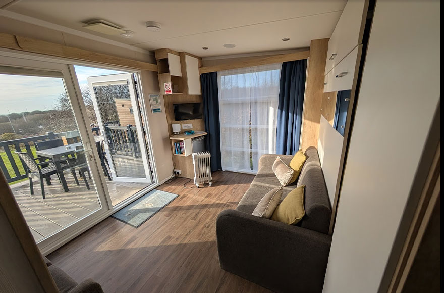 Glamping pod interior view from the corner looking out with the sun shining inside the cabin