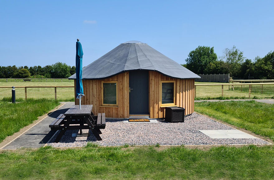 wooden yurt with a picnic table