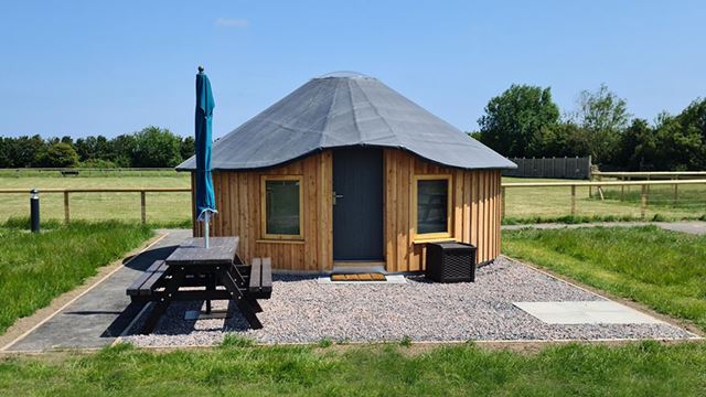 wooden yurt with a picnic table
