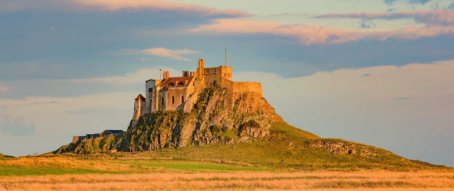 a stone built house sits atop hill basking in golden sunlight