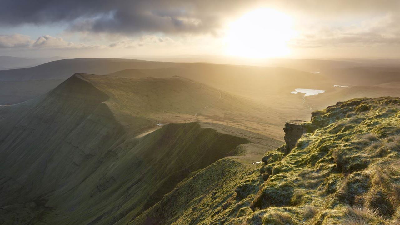 the rocky terrain hilltops of Powys bathed in soft sunlight