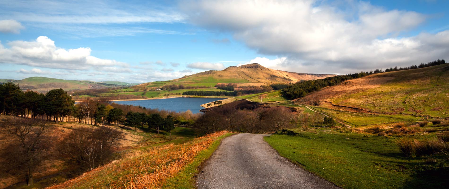 View of a winding road, mountains and lakes in the Peak District.