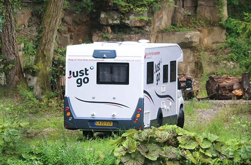 Just go motorhome in a woodland area surrounded by trees and plants 