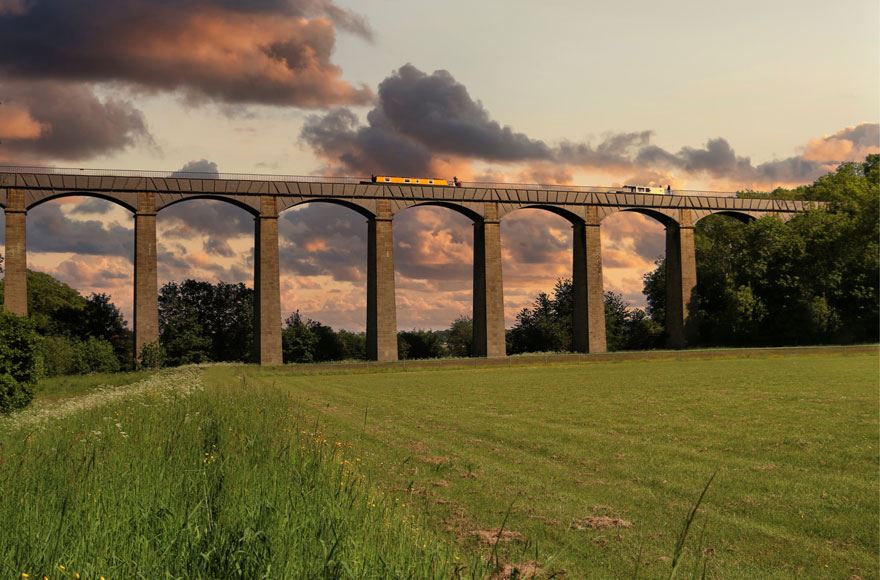 two narrowboats cross the aqueduct at sunset