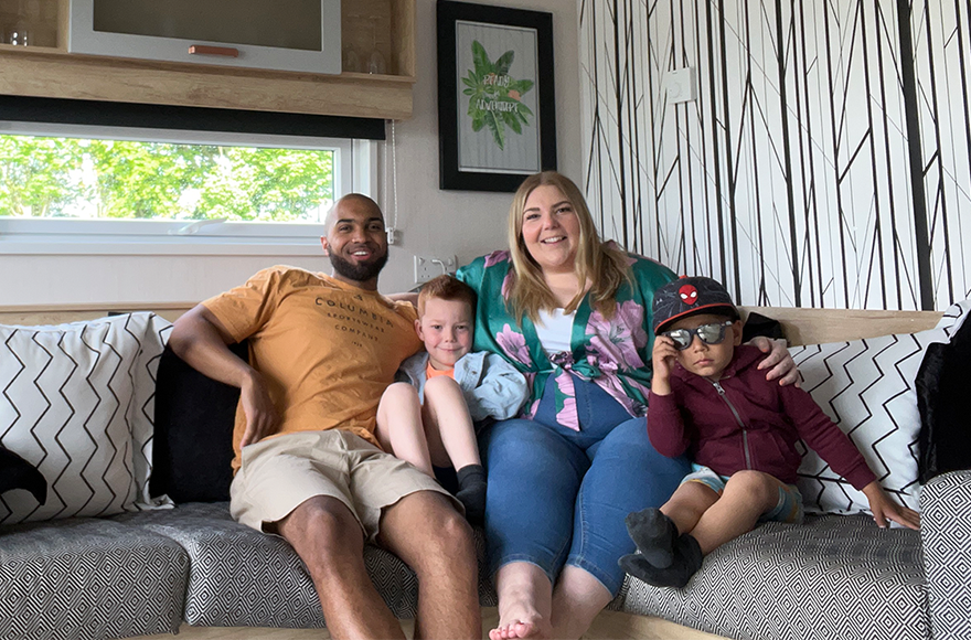 Family of 4 relaxing on a sofa in a glamping cabin