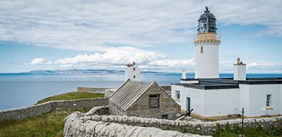 a lighthouse stands looking over a calm sea
