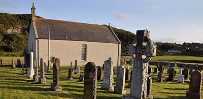 Strathnaver Museum surrounded by graves bathed in sunlight