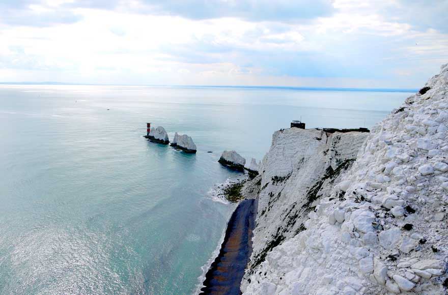 A panoramic view of the iconic needles chalk rocks, showcasing their majestic height against a clear blue sky