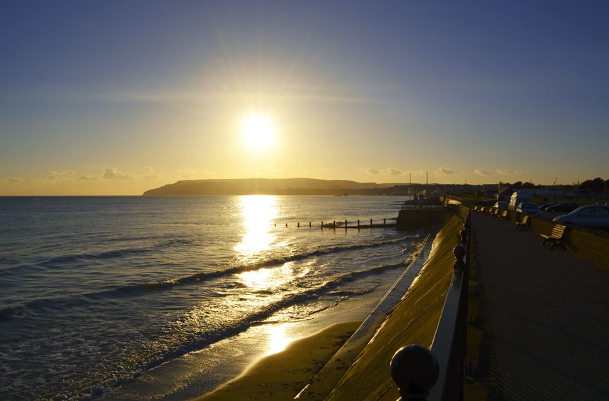 A tranquil Shanklin beach setting showcasing a bench facing the ocean,