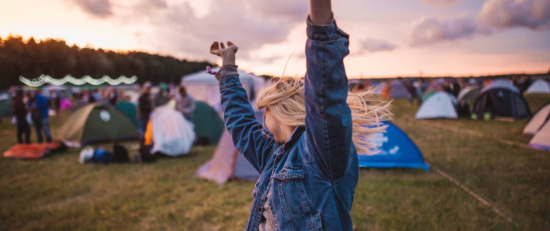 Girl dancing around tents at a UK festival