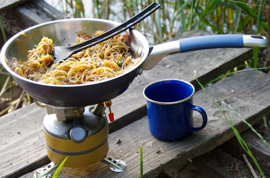 Pasta being cooked on a camping stove outside