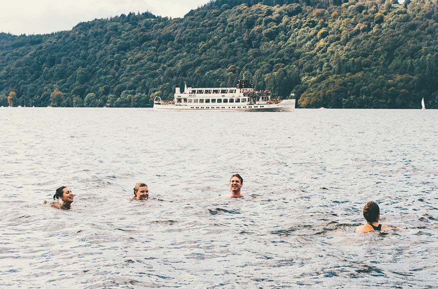 Group of four friends swimming in Lake Windermere, Lake District.